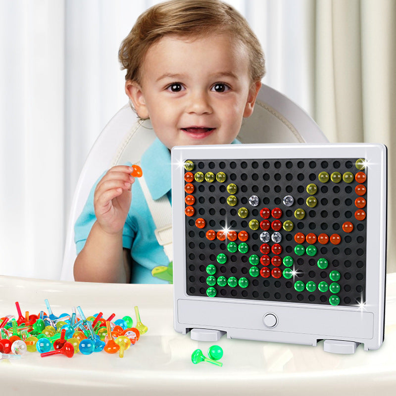 Toddler placing a colorful pixel tile into the illuminated mosaic display board