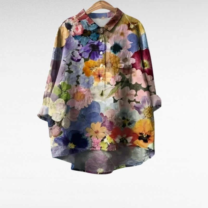 Women's floral long sleeve summer blouse in multicolor hanging on a wooden hanger.