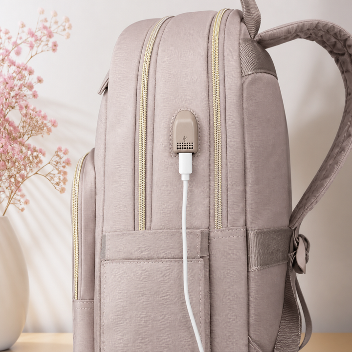 Close-up view of the pink women's tech backpack highlighting the integrated USB port and zipper details