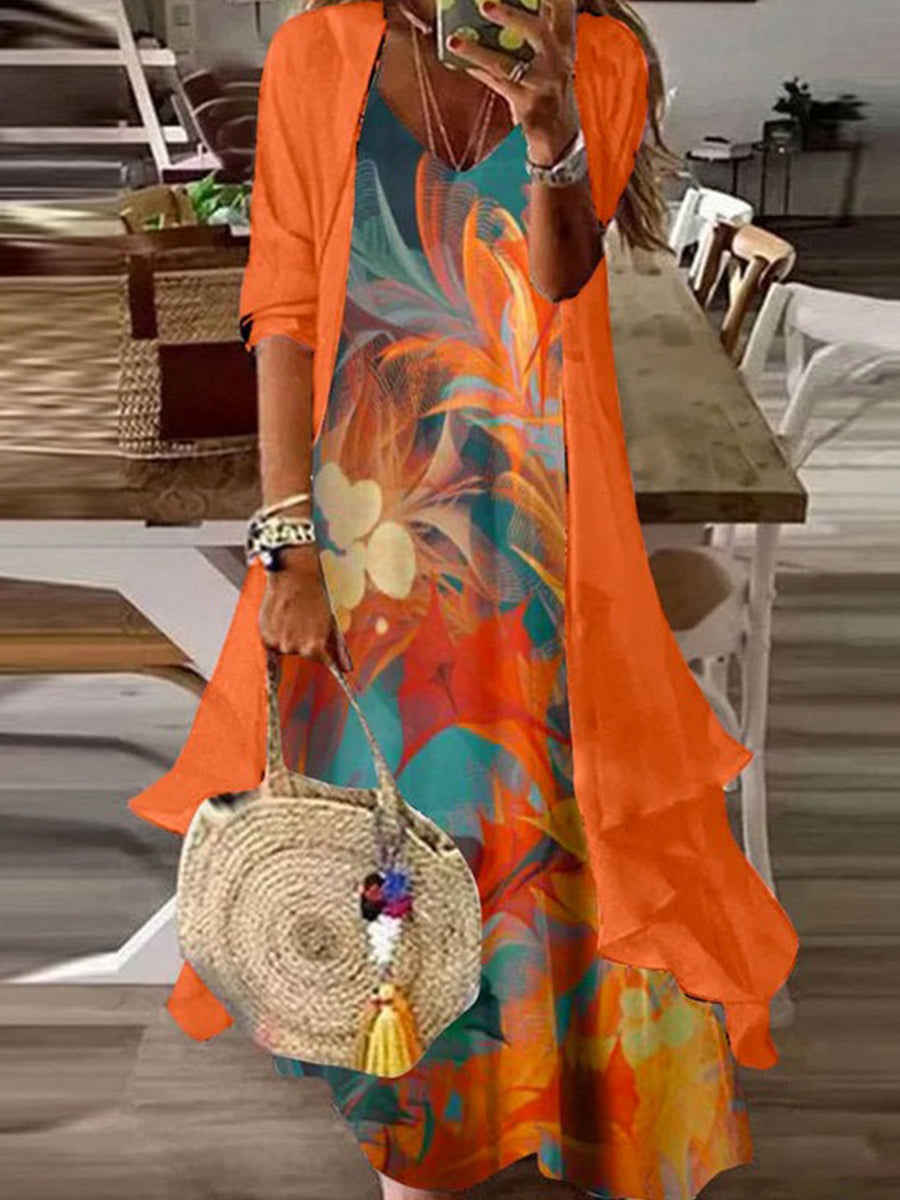 Woman wearing an orange print dress and matching jacket set holding a woven handbag