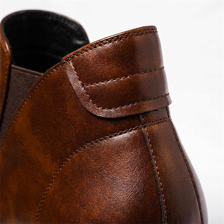 Pair of men's hand-crafted leather Chelsea boots in cognac brown showing the elastic side panels