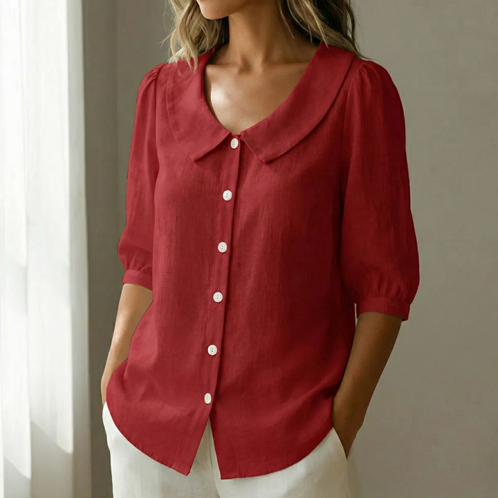 Woman wearing a red retro Peter Pan collar button-up blouse