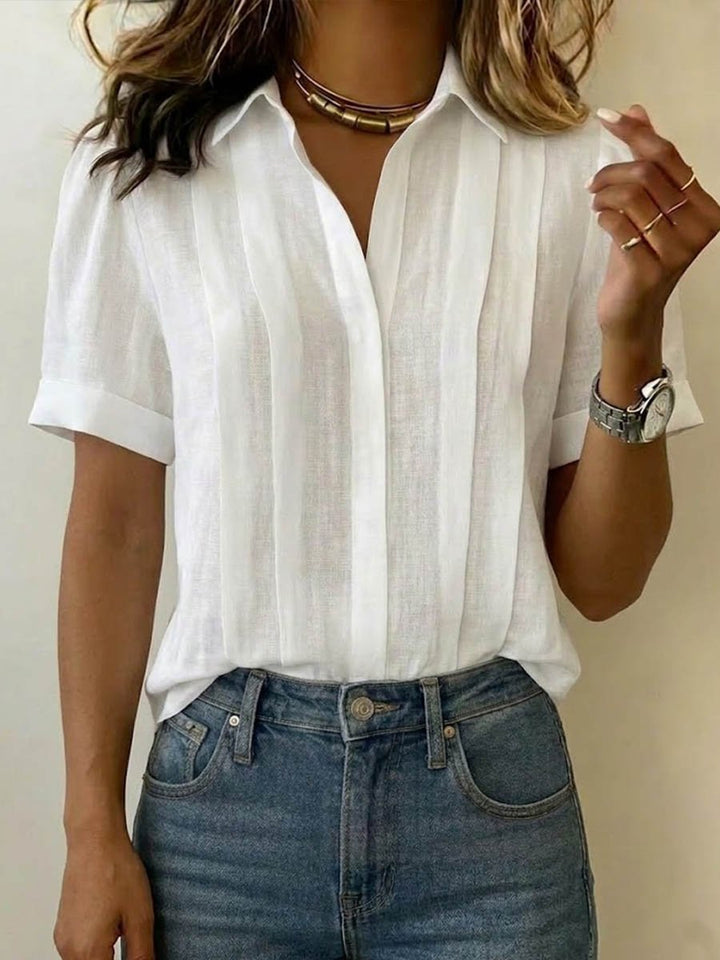 Woman wearing white short-sleeve collared blouse with denim jeans