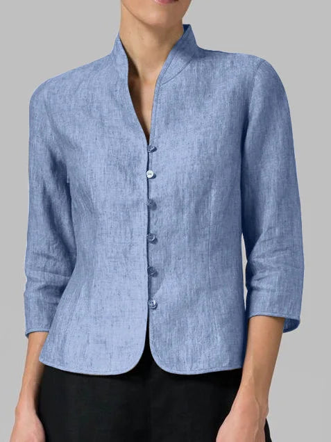 Woman wearing blue mandarin collar button-front blouse paired with black trousers