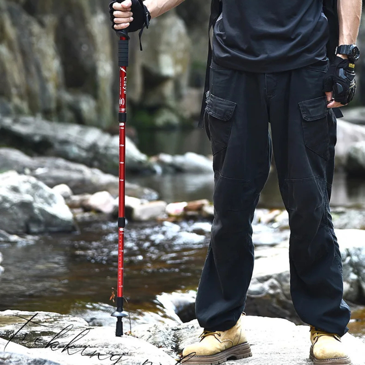 Backpacker carrying telescopic hiking sticks attached to a travel backpack
