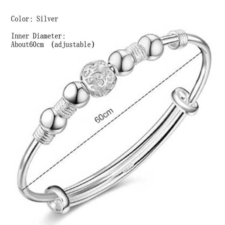 Close-up of sterling silver charm and beads on a minimalist bracelet
