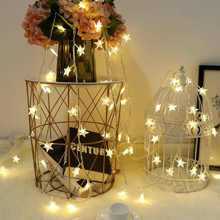 Warm white star LED string lights glowing softly in a cozy bedroom decor setting