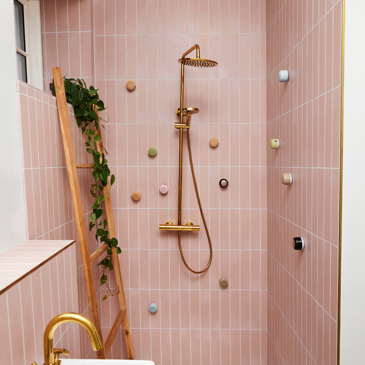 Bathroom speaker paired with a smartphone displaying music streaming app
