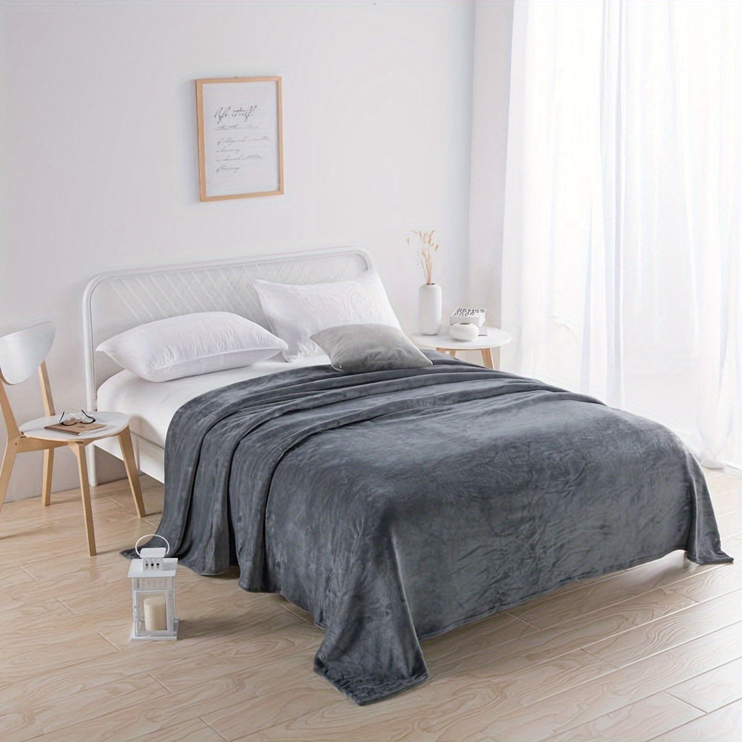 Luxurious grey flannel blanket elegantly draped over a modern white bed