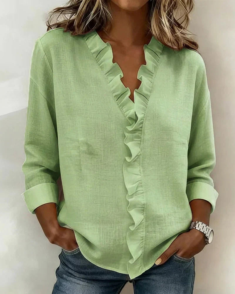 Woman wearing green lightweight V-neck ruffled blouse