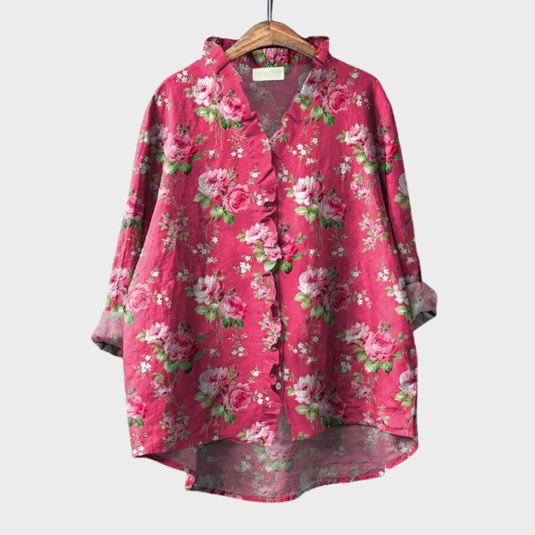 Pink floral summer blouse hanging on a wooden hanger showing front details