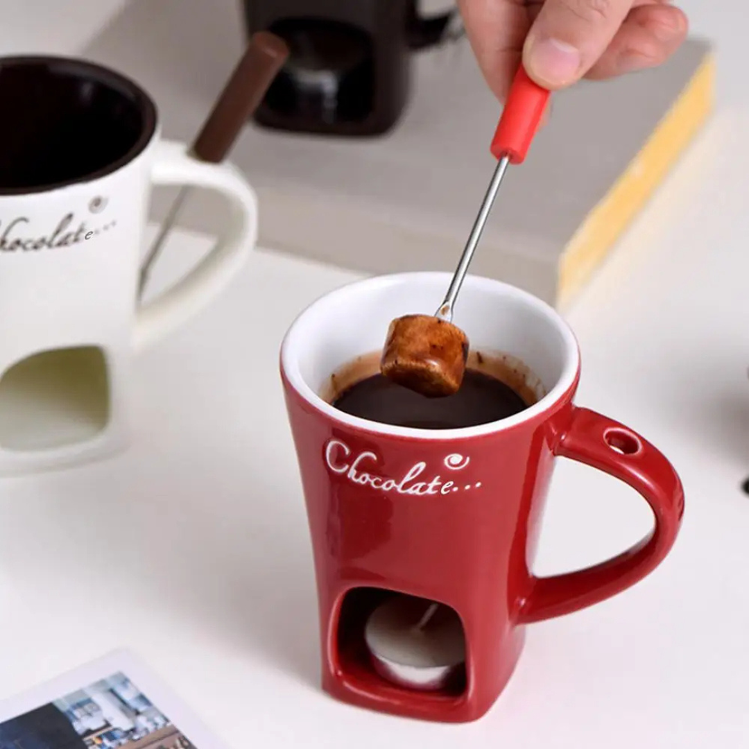 White ceramic fondue mug with dipping fork and melted chocolate