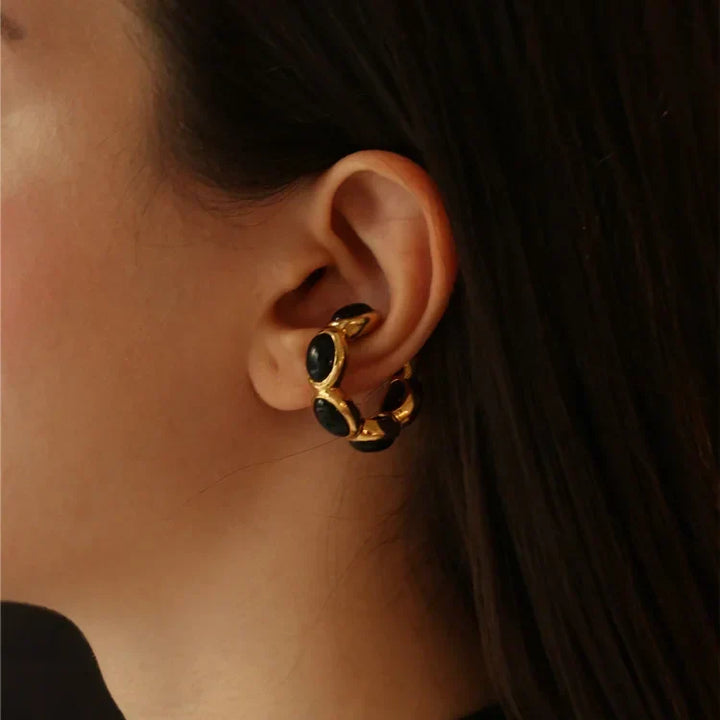 Woman wearing the gold-plated black stone piece as an ear cuff