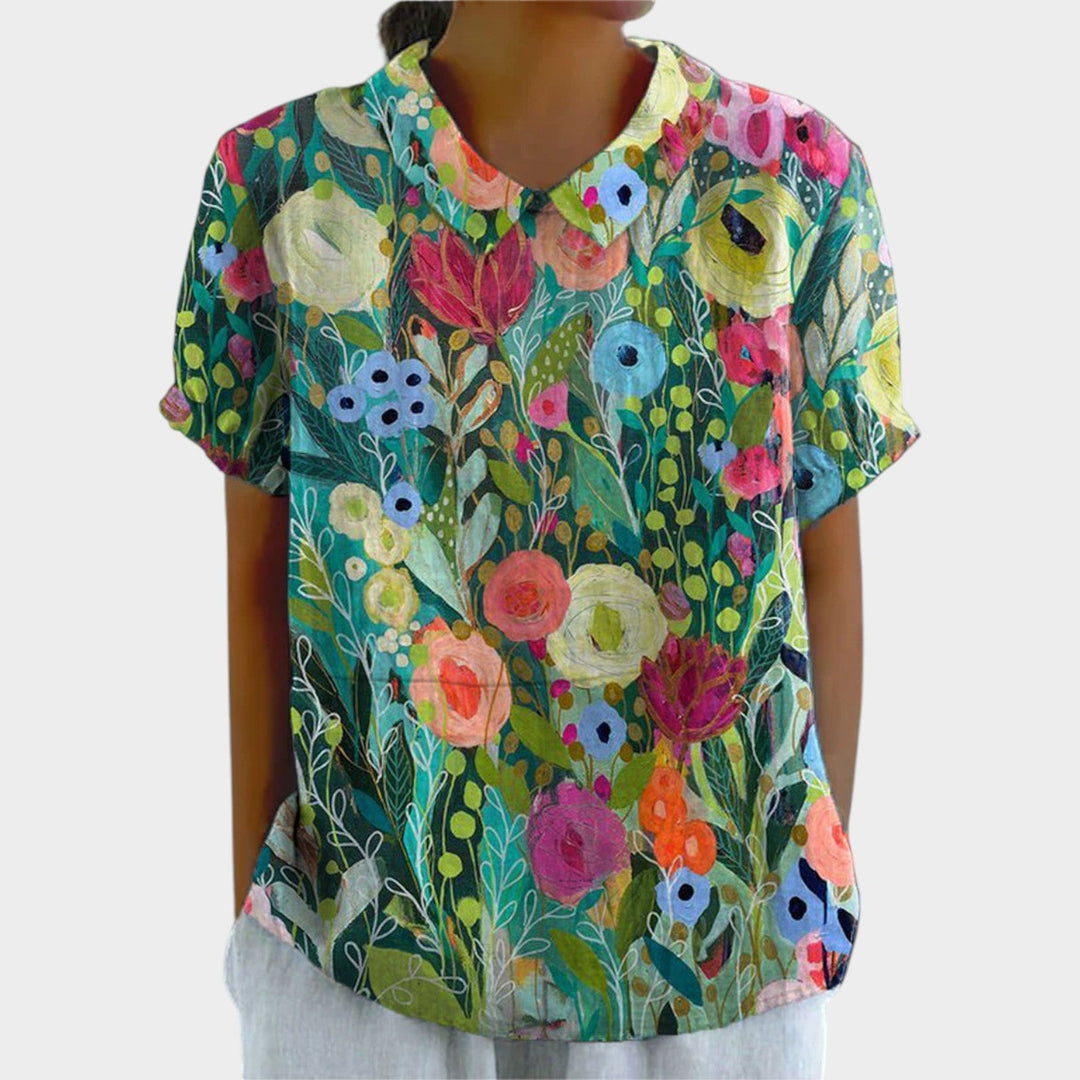 Woman wearing a multicolor floral print short sleeve blouse with a round neckline