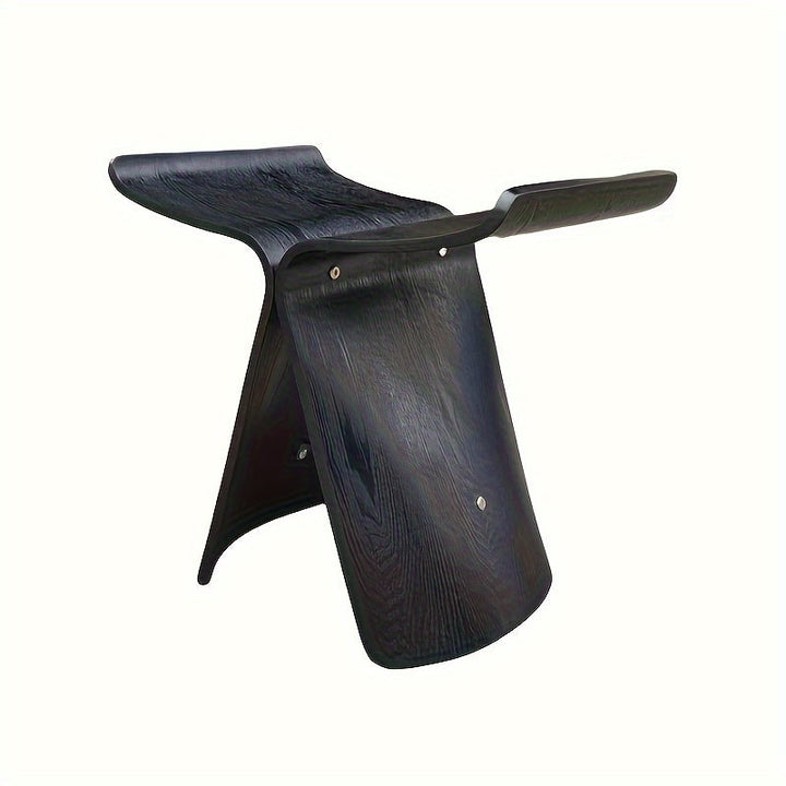 Modern wooden butterfly stool viewed from a three-quarter angle in a living room