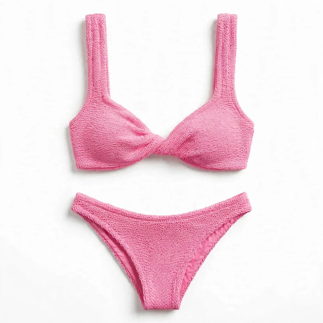 Flat lay view of the pink twist front textured bikini set top and bottoms