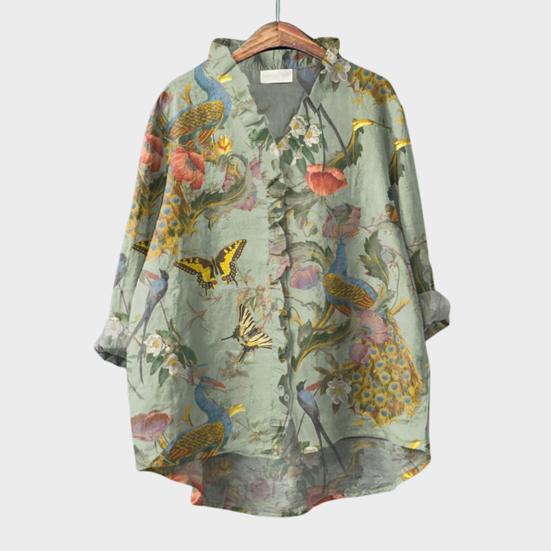 Women's green floral print summer blouse hanging on a wooden hanger