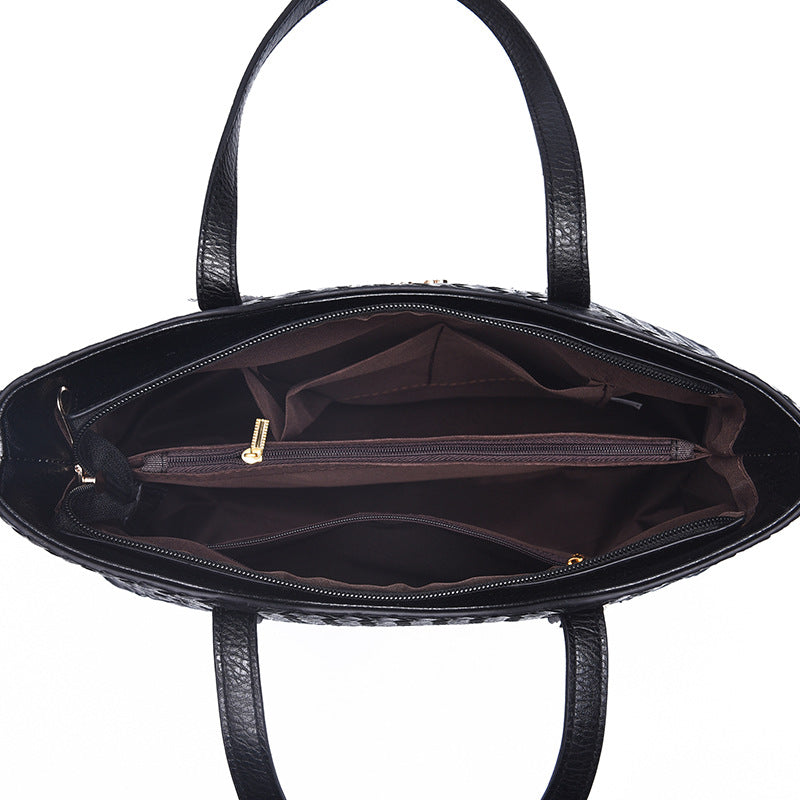 Top view of open black handbag interior with multiple compartments and dividers