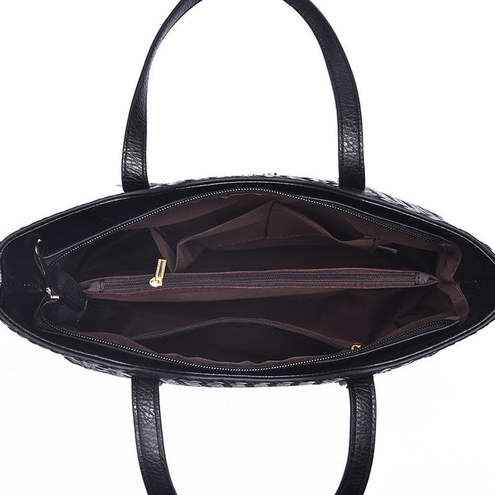 Top view of open black handbag interior with multiple compartments and dividers