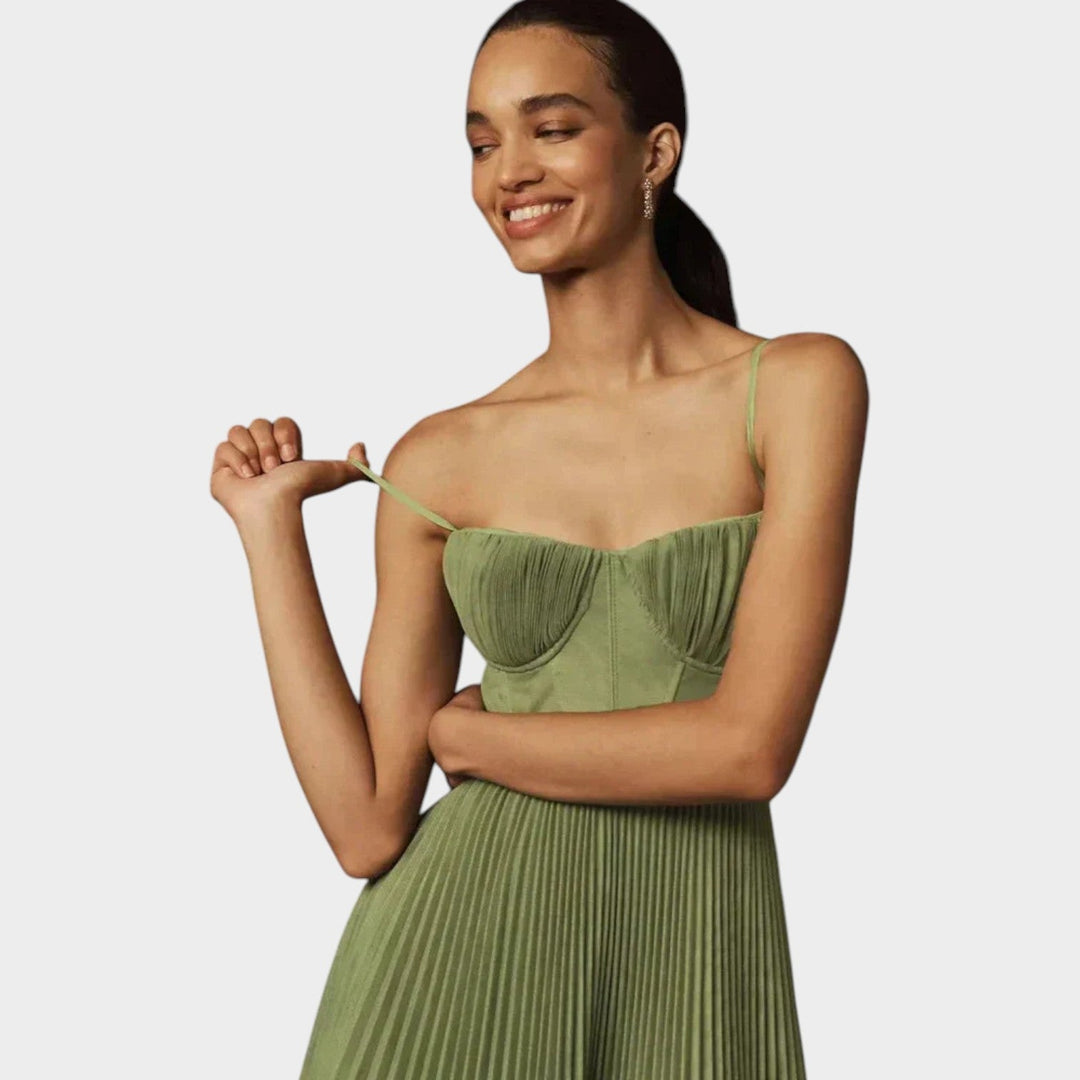 Close-up of the green pleated dress showing adjustable straps and bodice