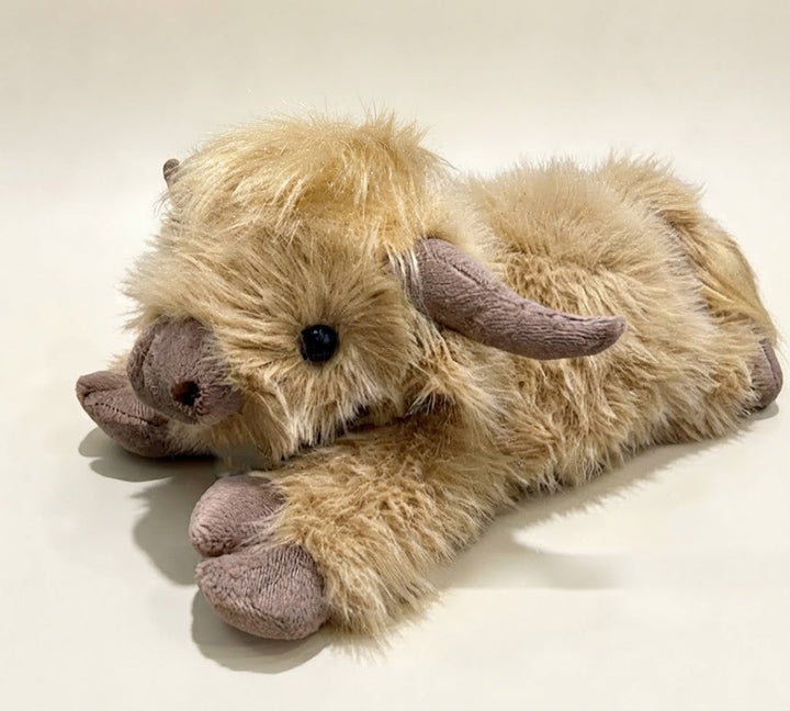 Close-up of the stuffed Highland cow's friendly face, embroidered eyes, and cute snout.