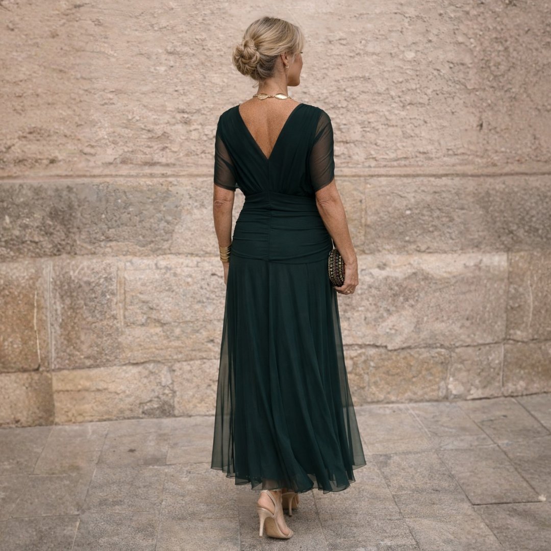Back view of a woman wearing the elegant dark green off-shoulder maxi dress with a sophisticated updo hairstyle.
