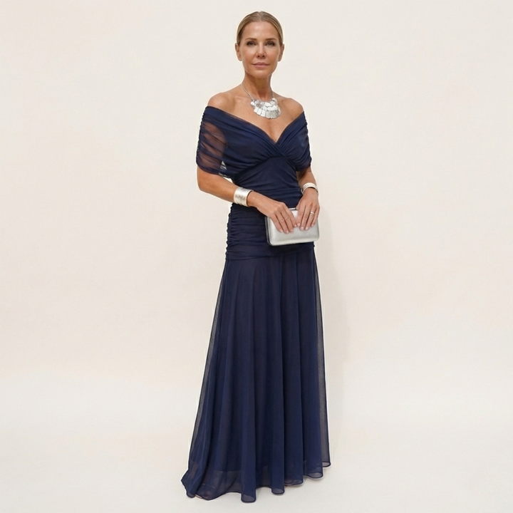 Woman showcasing a deep blue flowing maxi dress with classic styling