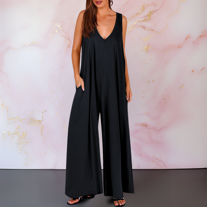 Woman wearing a black wide leg sleeveless V-neck jumpsuit with side pockets