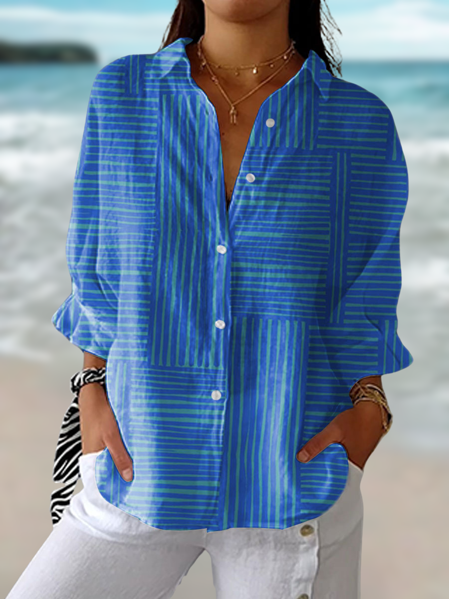 Woman wearing a blue striped button-down blouse with coastal background