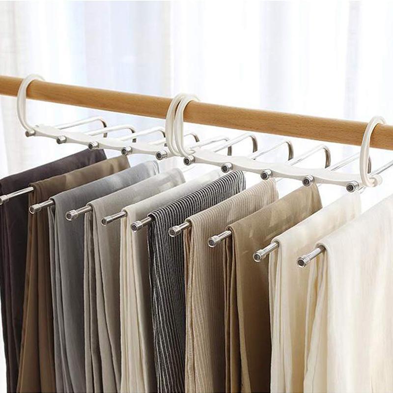 White multifunctional magic pants hanger holding multiple pairs of trousers in a closet