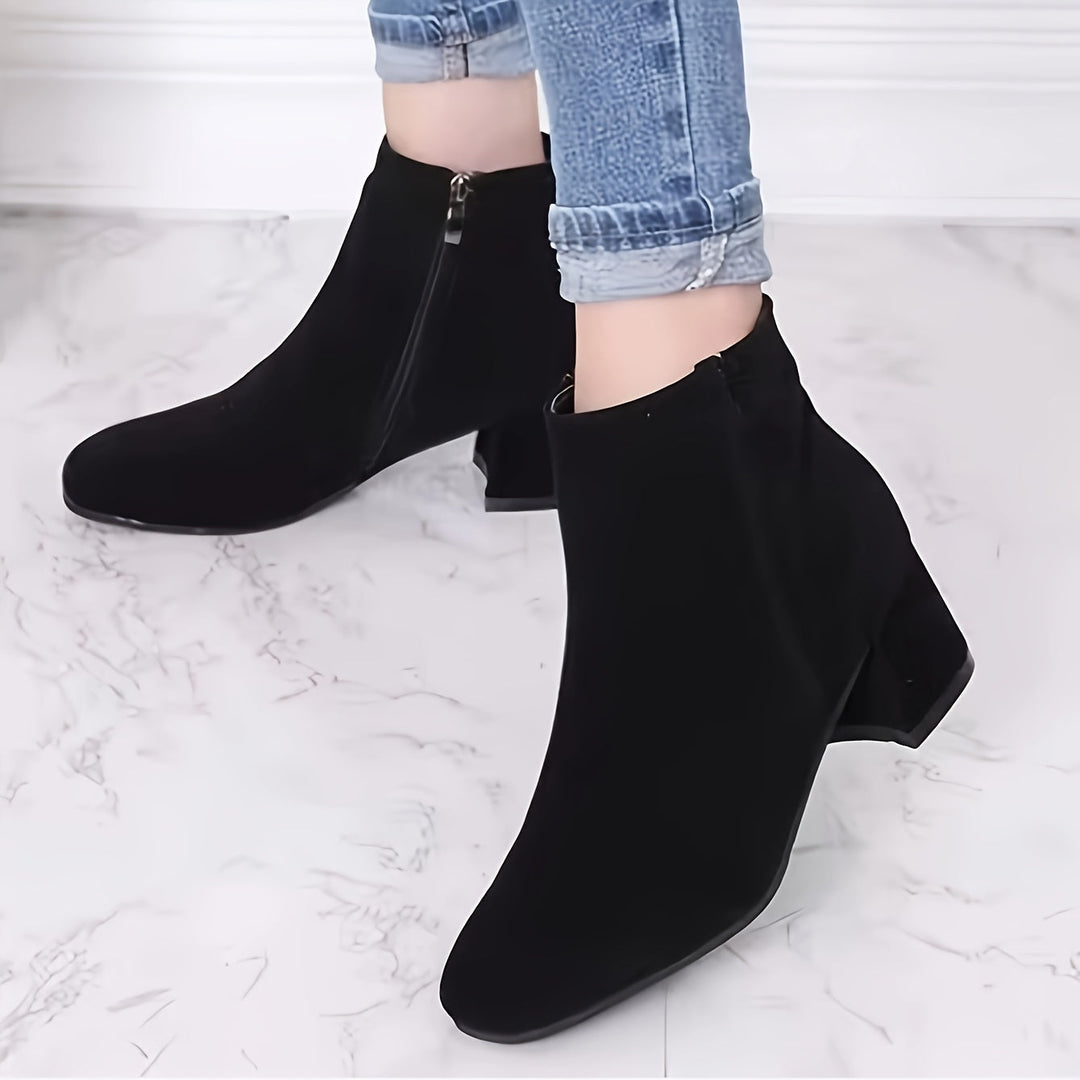 Pair of womens black boots arranged neatly on a neutral background