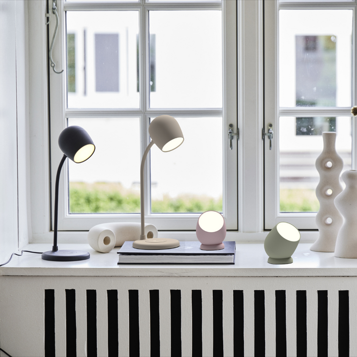 Flexible gooseneck of the smart LED desk lamp pointing over an open book