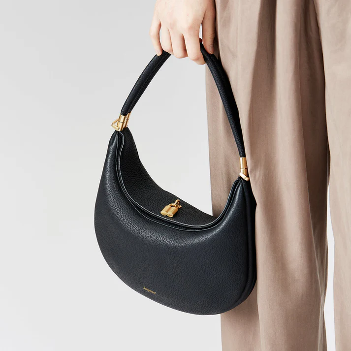Woman holding black chic handbag by the top handle