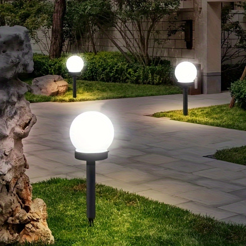 Outdoor solar lamps illuminating a garden landscape and flower bed during twilight.