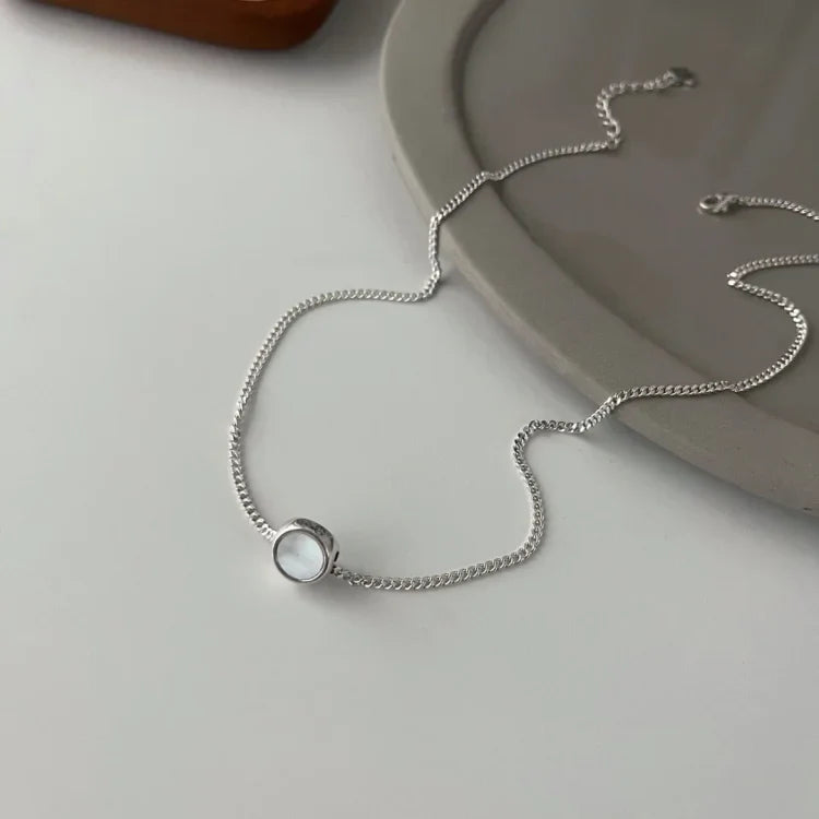 Display of the white side of the reversible smiley pendant necklace