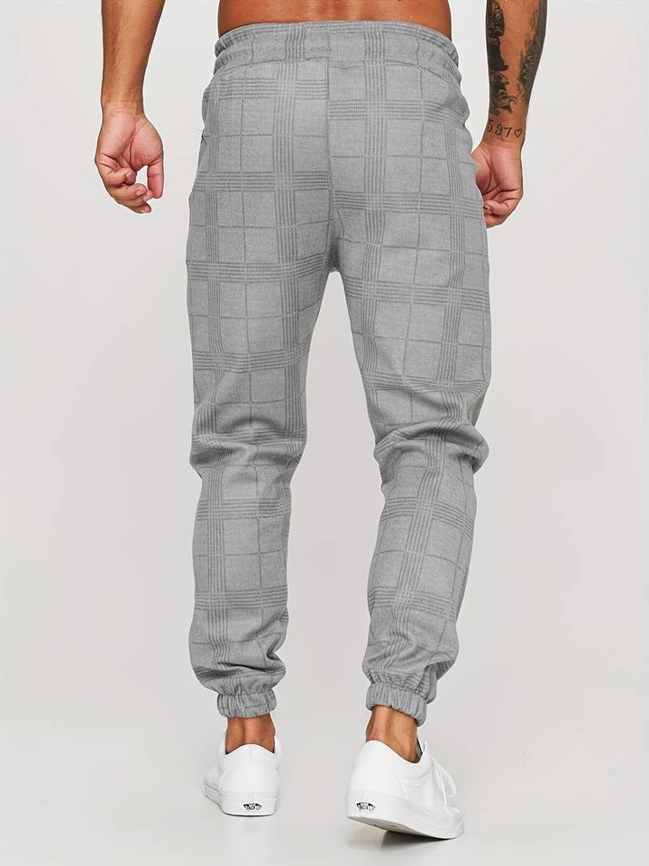 Men's modern checked jogger pants featuring an adjustable drawstring waist and tapered fit.