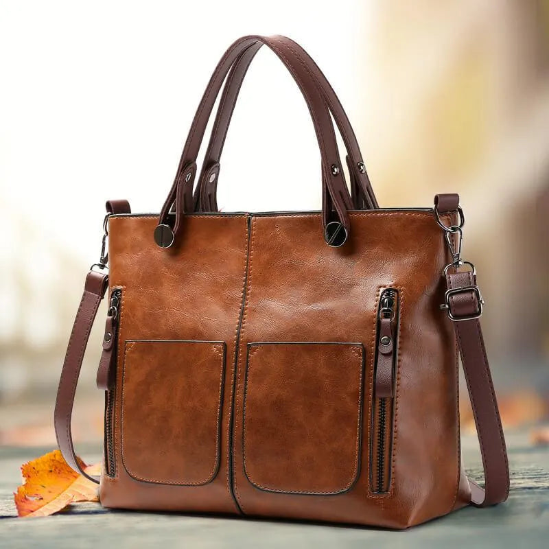 Women's brown leather shoulder bag with front pockets and top handles