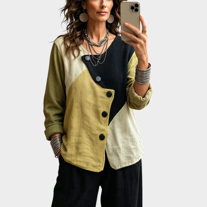Woman wearing an asymmetric colourblock top with diagonal buttons and rolled-up cuffs