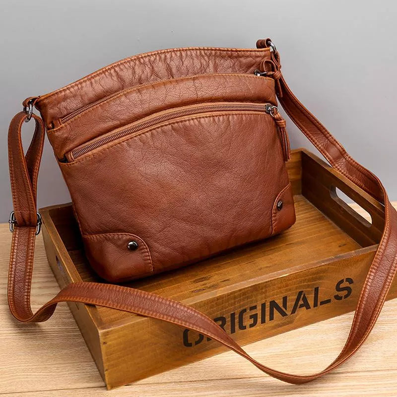 Brown Zoe shoulder bag displayed on a wooden crate