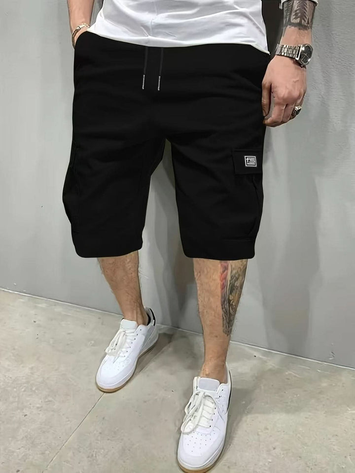 Man wearing black modern relaxed style utility shorts with white sneakers
