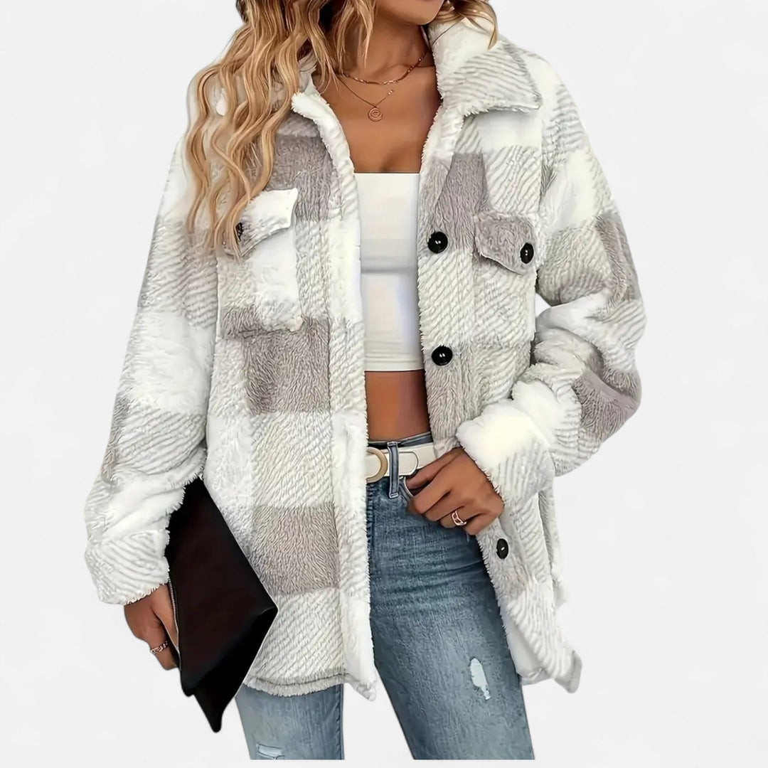 Close-up of a woman in a grey plaid shacket holding a clutch
