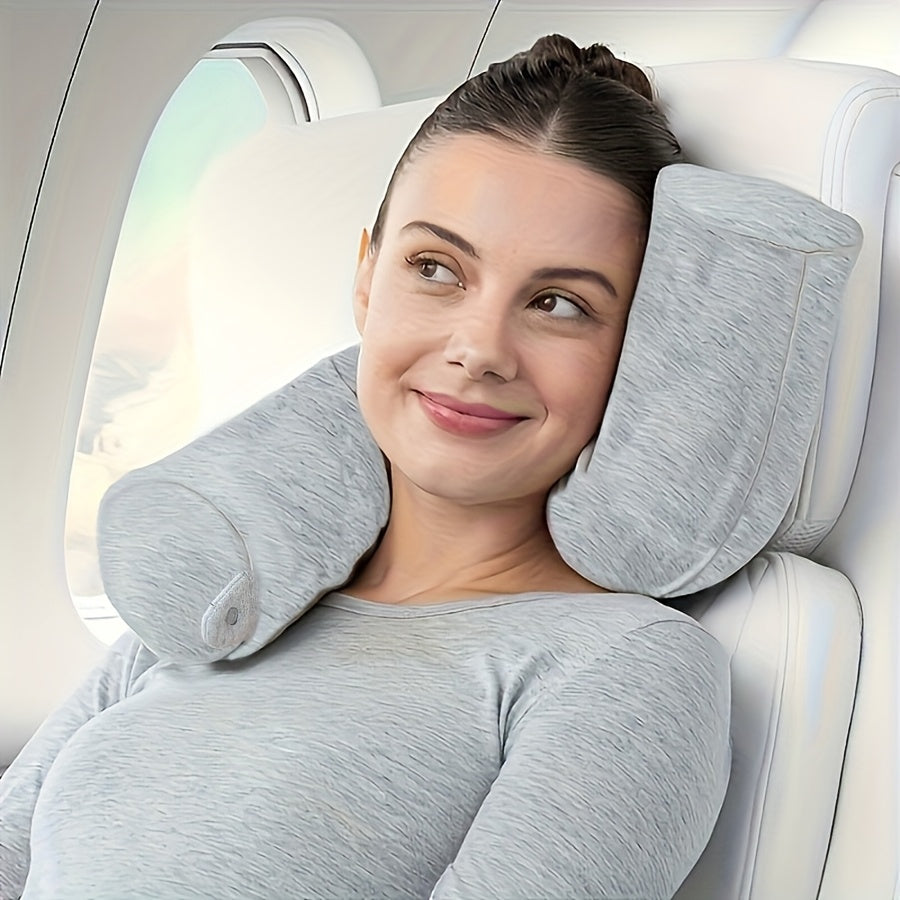 Woman relaxing in an airplane seat using a grey memory foam travel neck pillow
