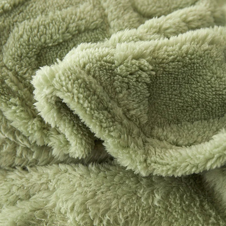 Close-up view of the soft textured fabric of the green bedroom blanket