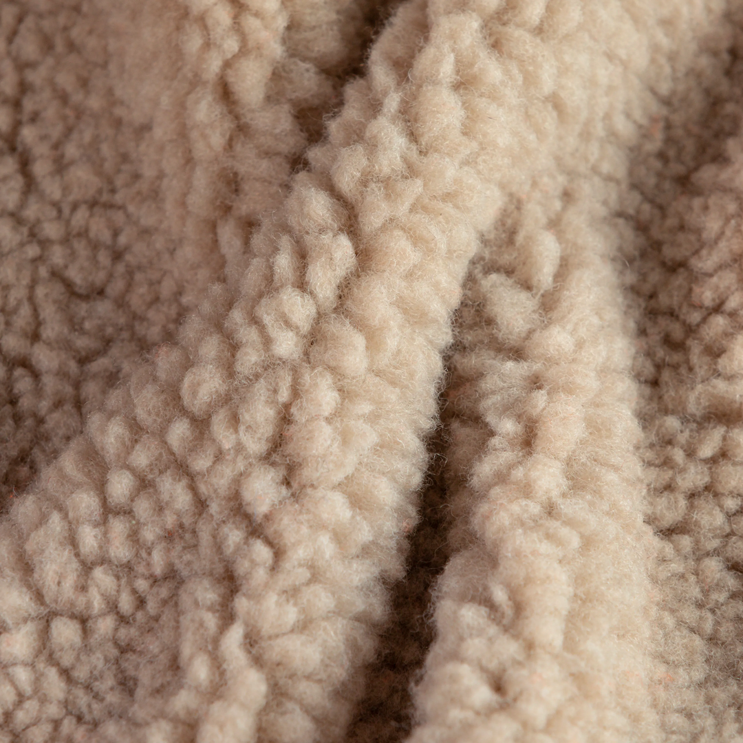 Close-up texture detail of the soft beige plush fabric