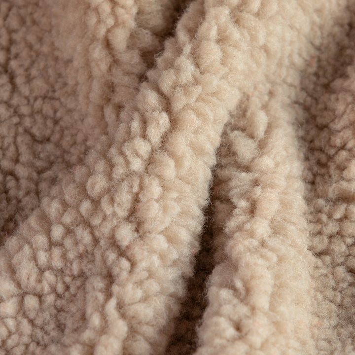 Close-up texture detail of the soft beige plush fabric