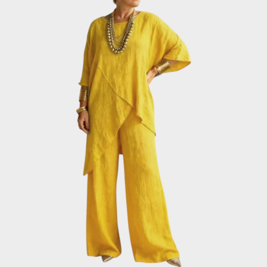 Woman wearing bright yellow asymmetrical two-piece matching set and statement jewelry