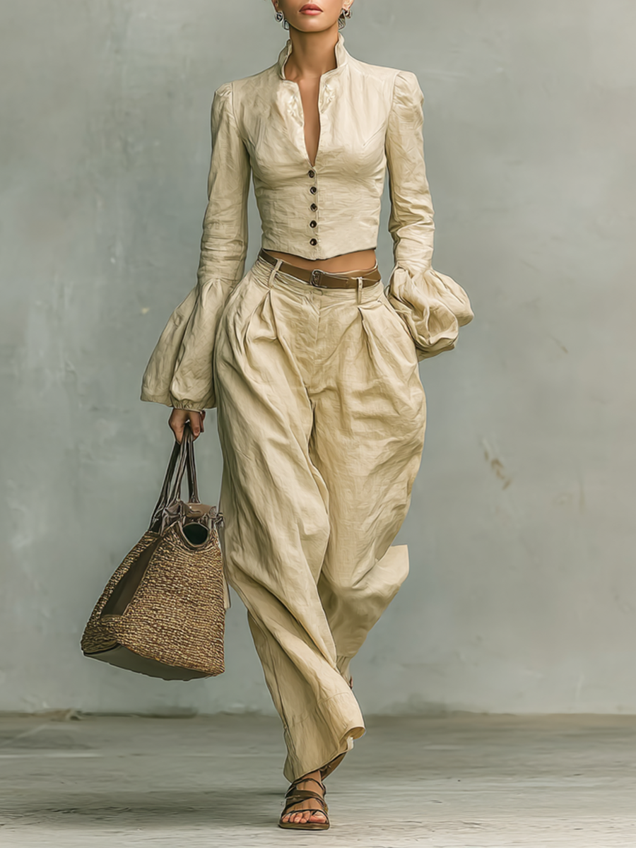 A model standing while wearing a stylish khaki shirt and trousers set with a woven handbag.