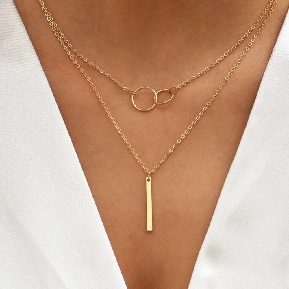 Women wearing a retro gold double circle pendant necklace paired with a vertical bar pendant.