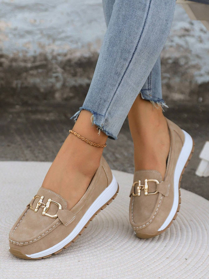 Woman wearing khaki comfort loafers with gold buckle and denim jeans