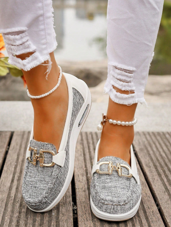 Detailed close-up of decorative gold buckle on womens loafers